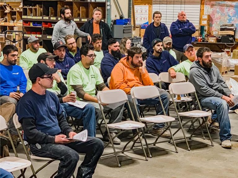 Group of technicians attending a training session in a workshop setting